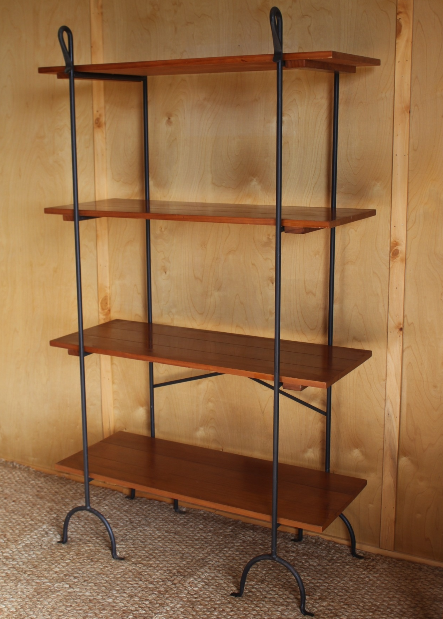 Wooden shelf with metal legs against a wooden wall.