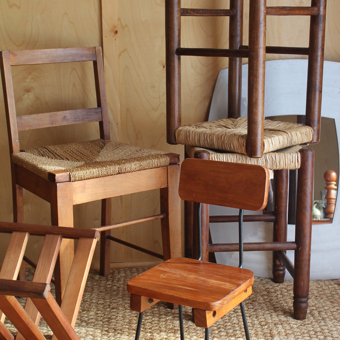 Wooden chair with metal legs against a textured wall.