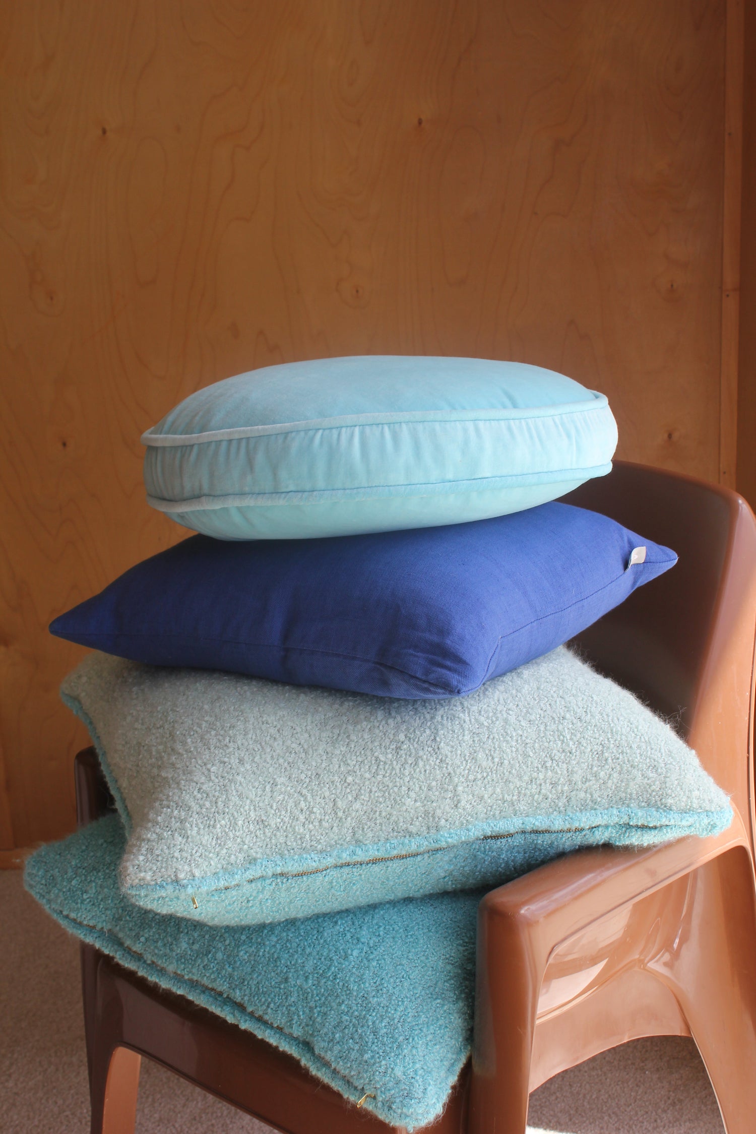 Cushions in blue shades stacked on chair