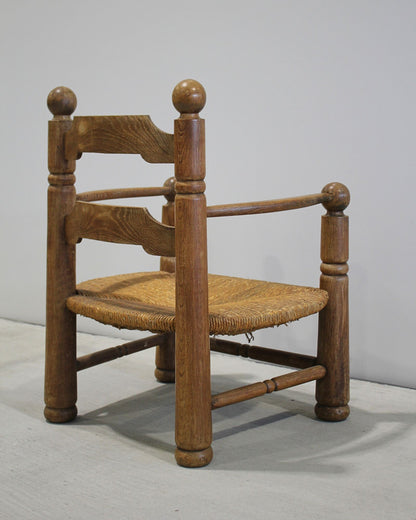 Charles Dudouyt carved timber fireside chair with woven rush seat, mid-century French design, sculptural ball finials, New Zealand