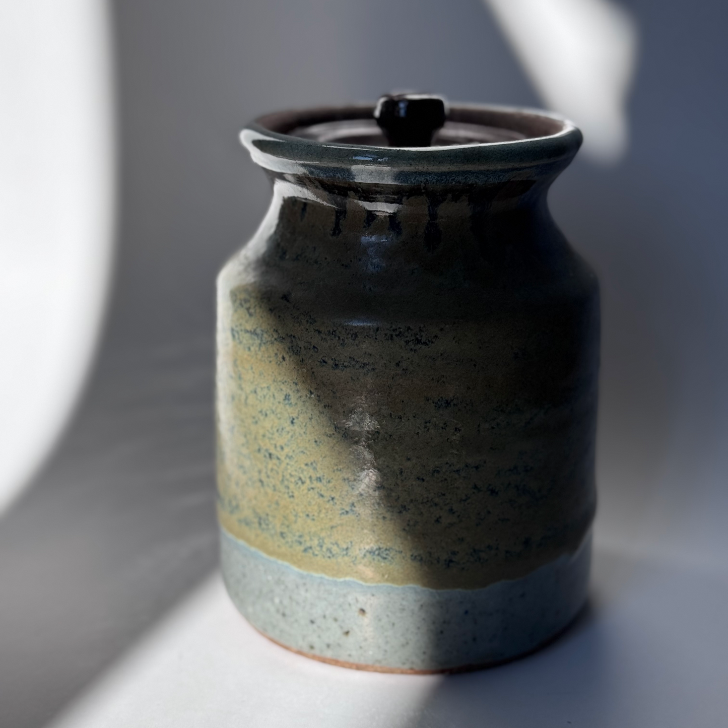 Ceramic jar with a lid on a gray background