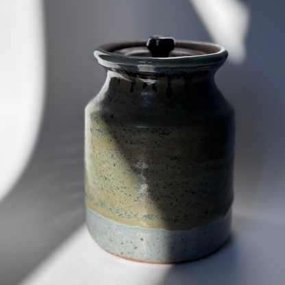 Ceramic jar with a lid on a gray background