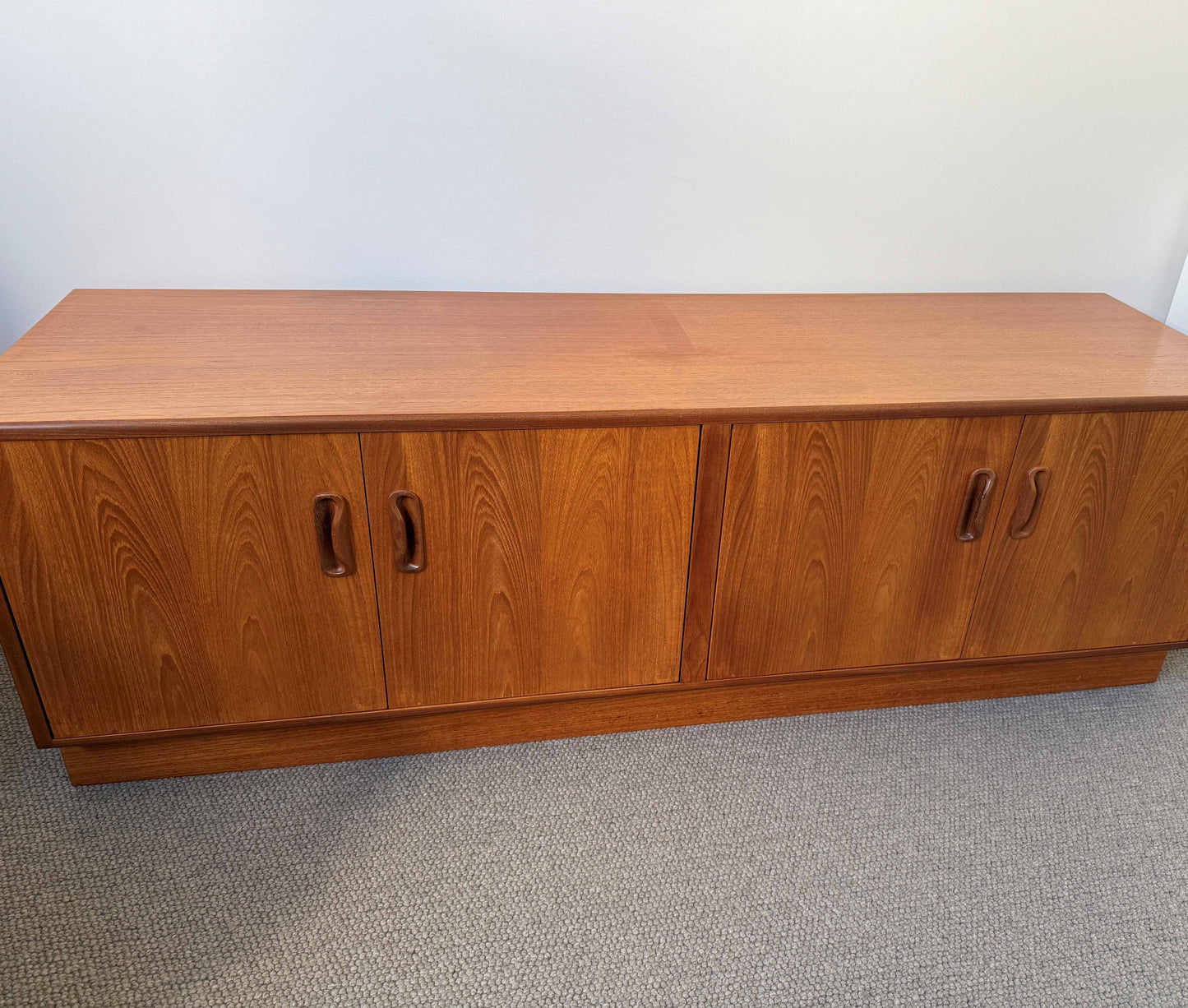 Wooden cabinet with two doors on a plain floor.