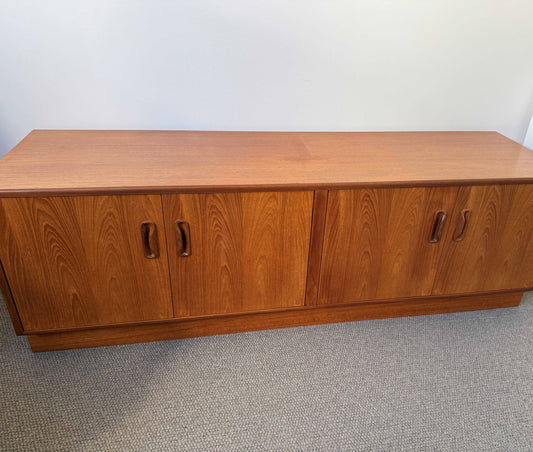 Wooden cabinet with two doors on a plain floor.