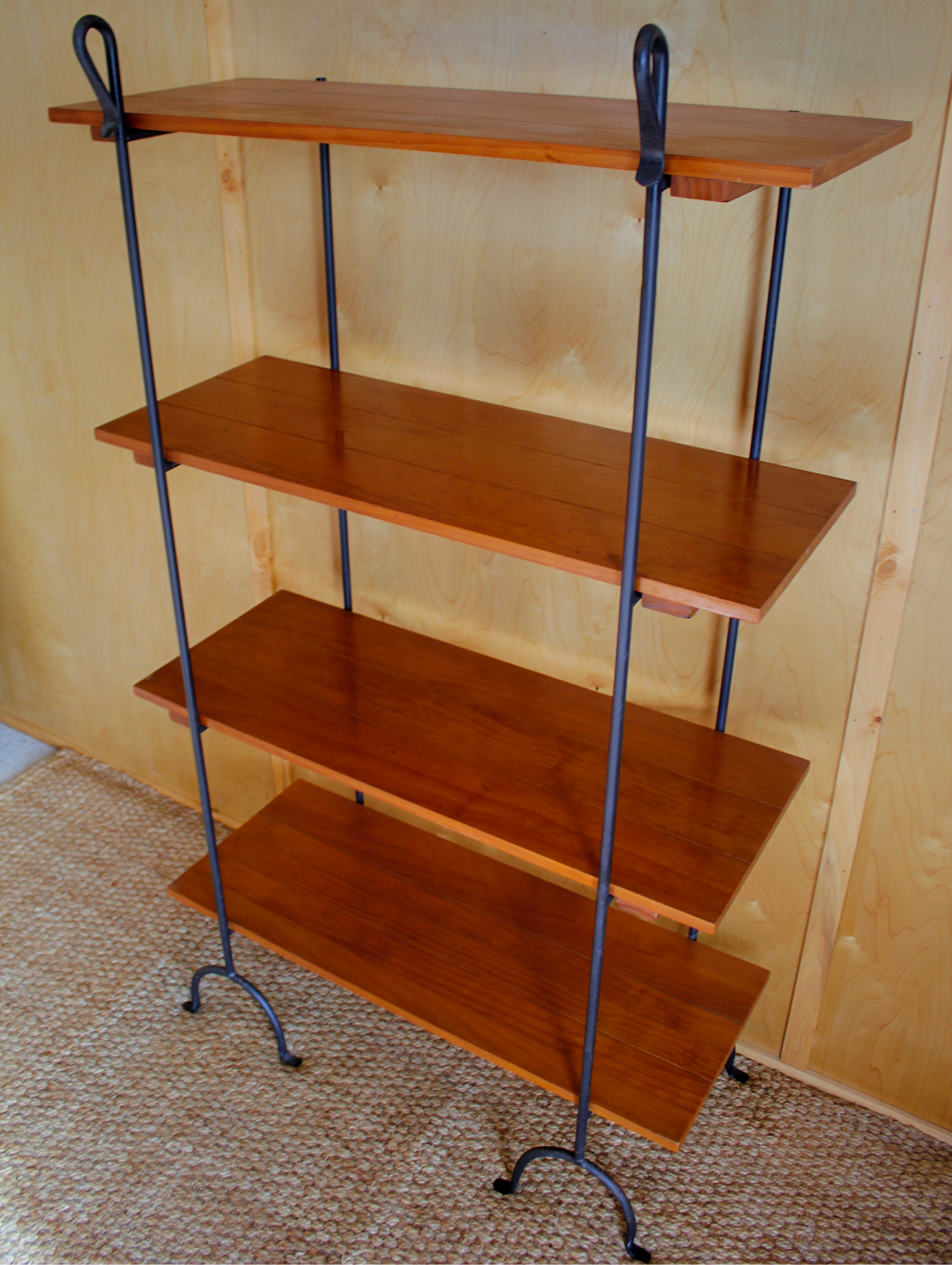 Wooden shelf with metal legs against a plain wall