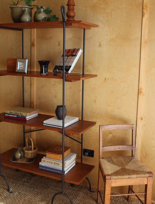Wooden shelf with books and decorative items against a wooden wall.