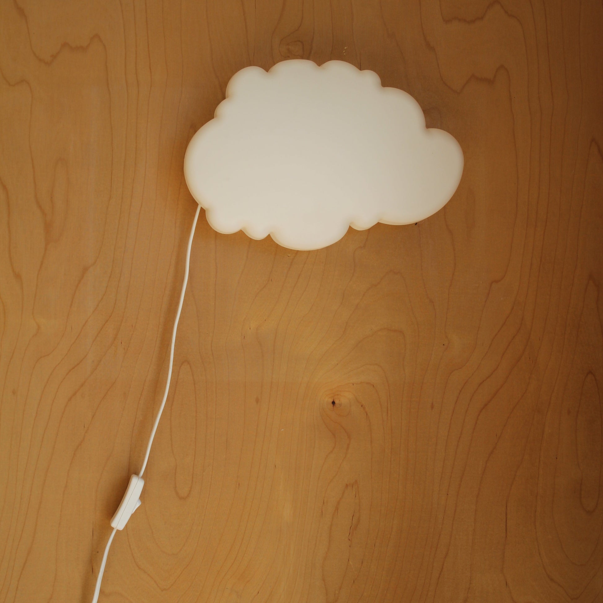 White cloud-shaped lamp on a wooden surface