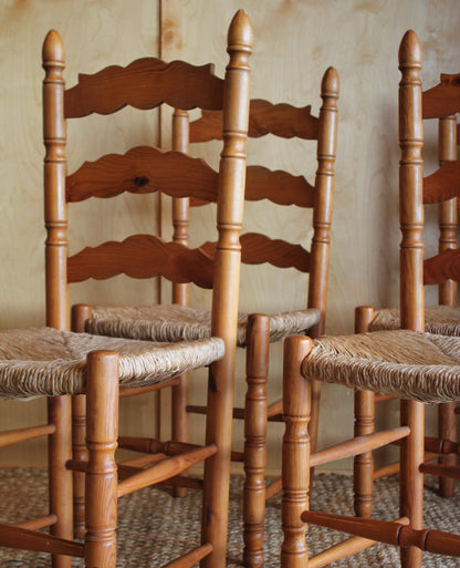 Wooden chair backrests stacked against a textured wall.