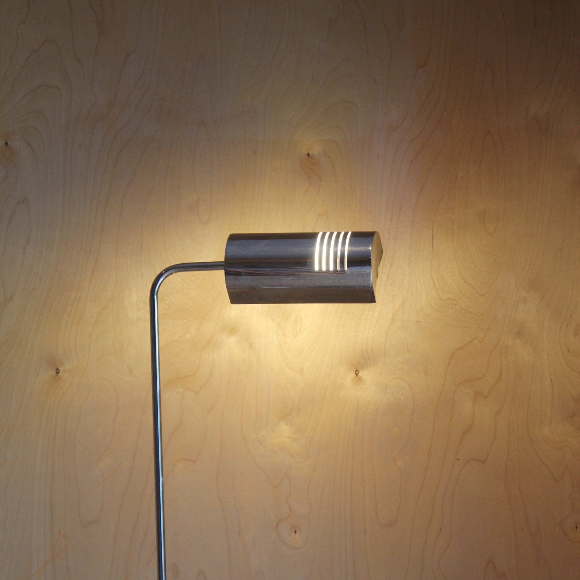 Modern wall-mounted light fixture on a wooden wall