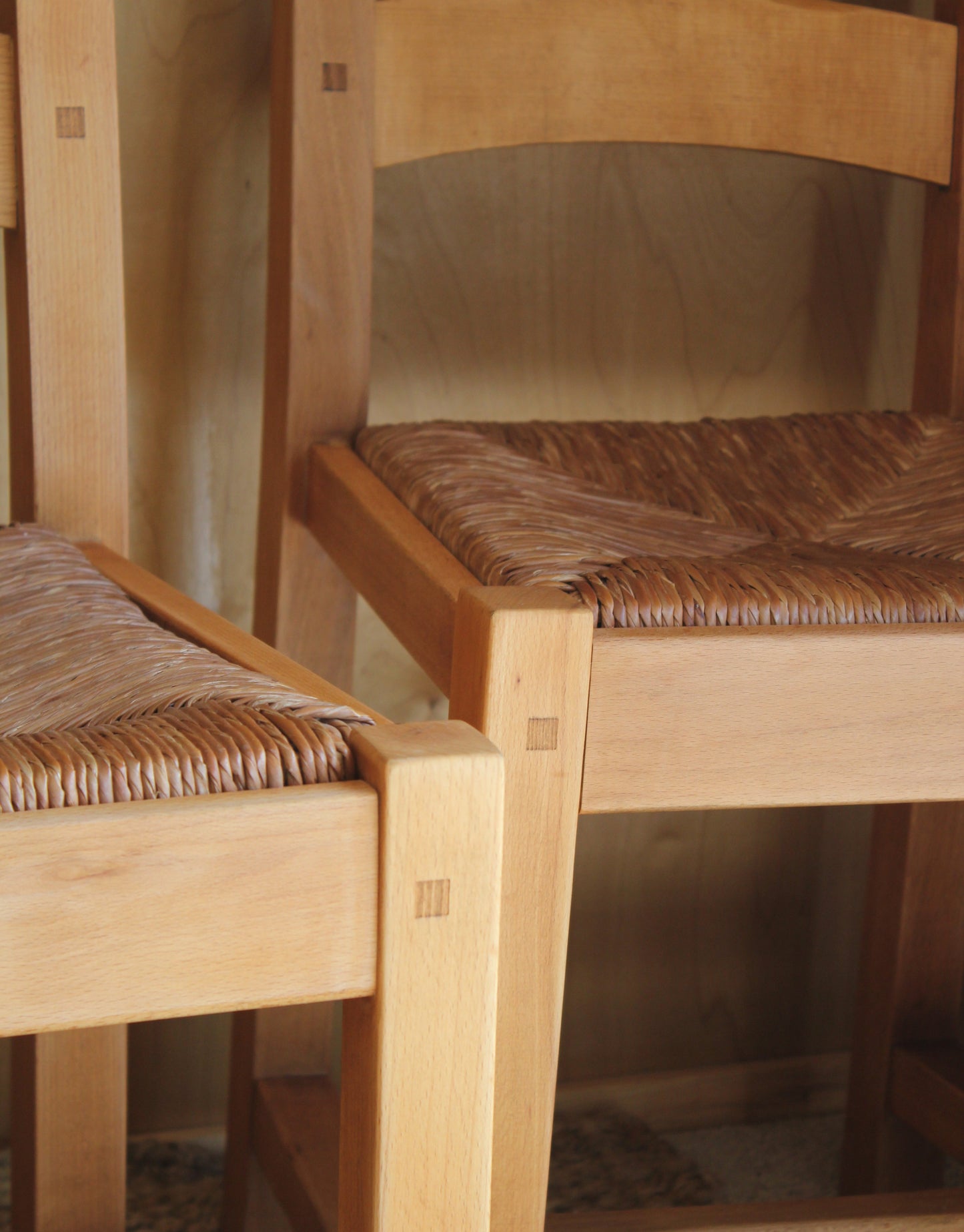 Close-up of a wooden chair with woven backrest