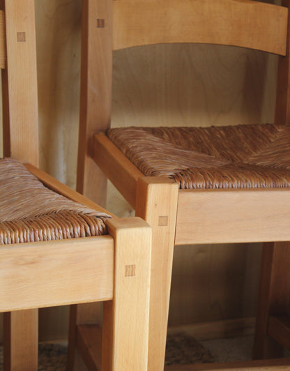Close-up of a wooden chair with woven backrest