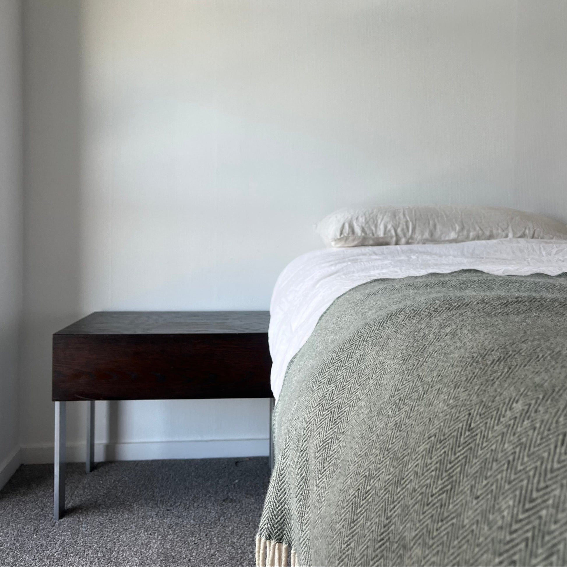 Bedroom with a bed, nightstand, and framed picture on the wall.