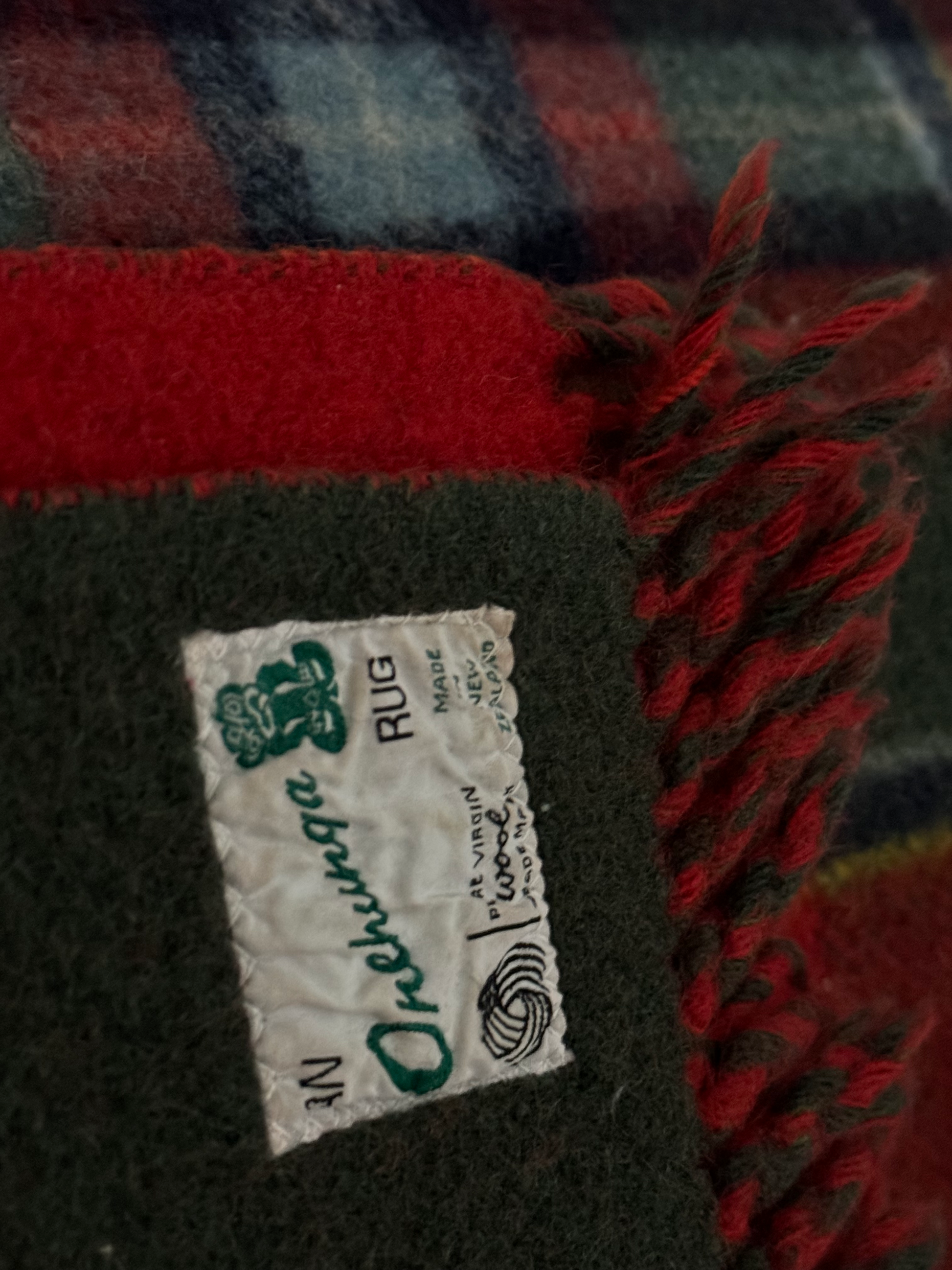 Close-up of a label on a plaid rug with red and green colors.