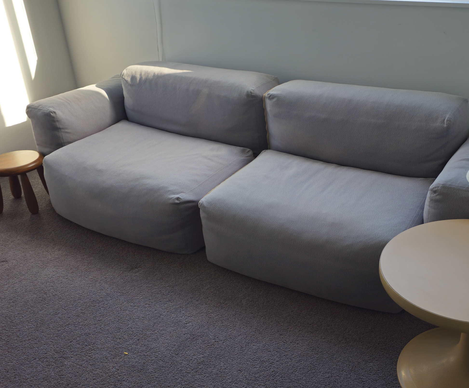 Gray sectional sofa in a room with a lamp and small table.