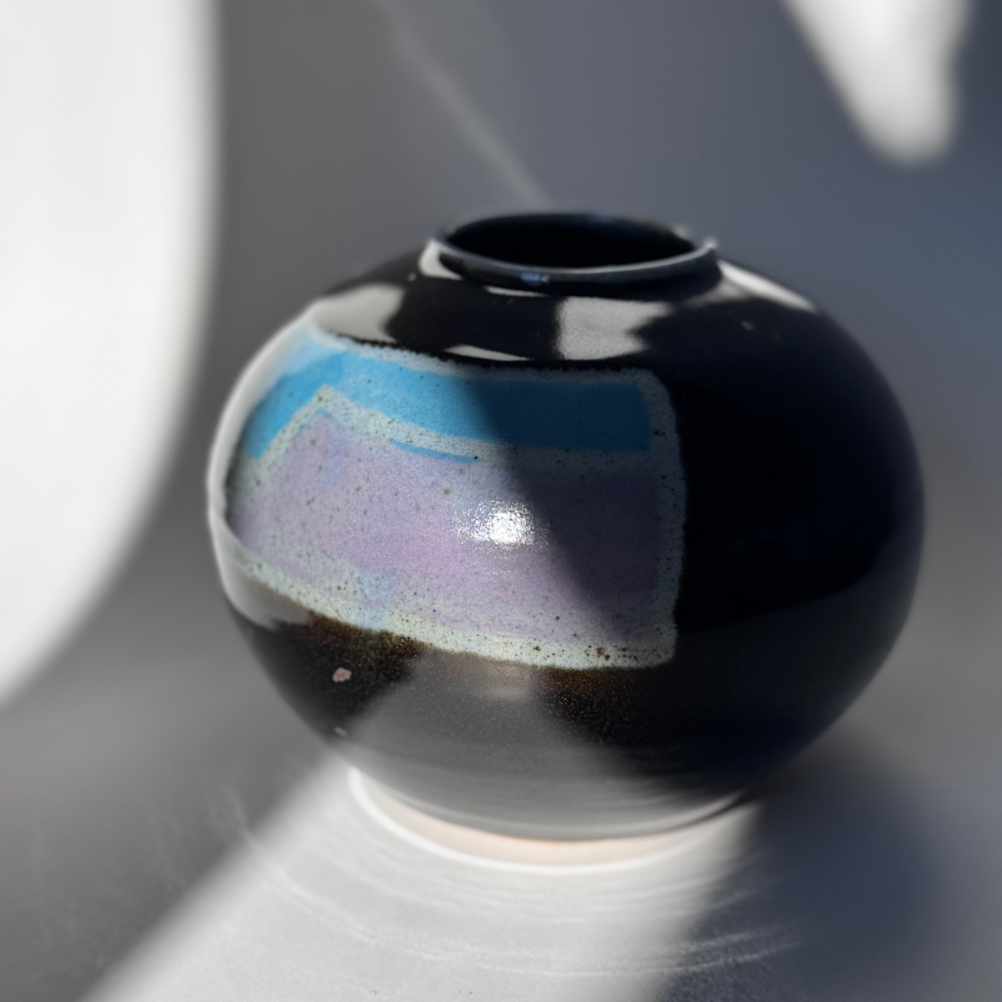 Black ceramic vase with a gradient finish on a gray background