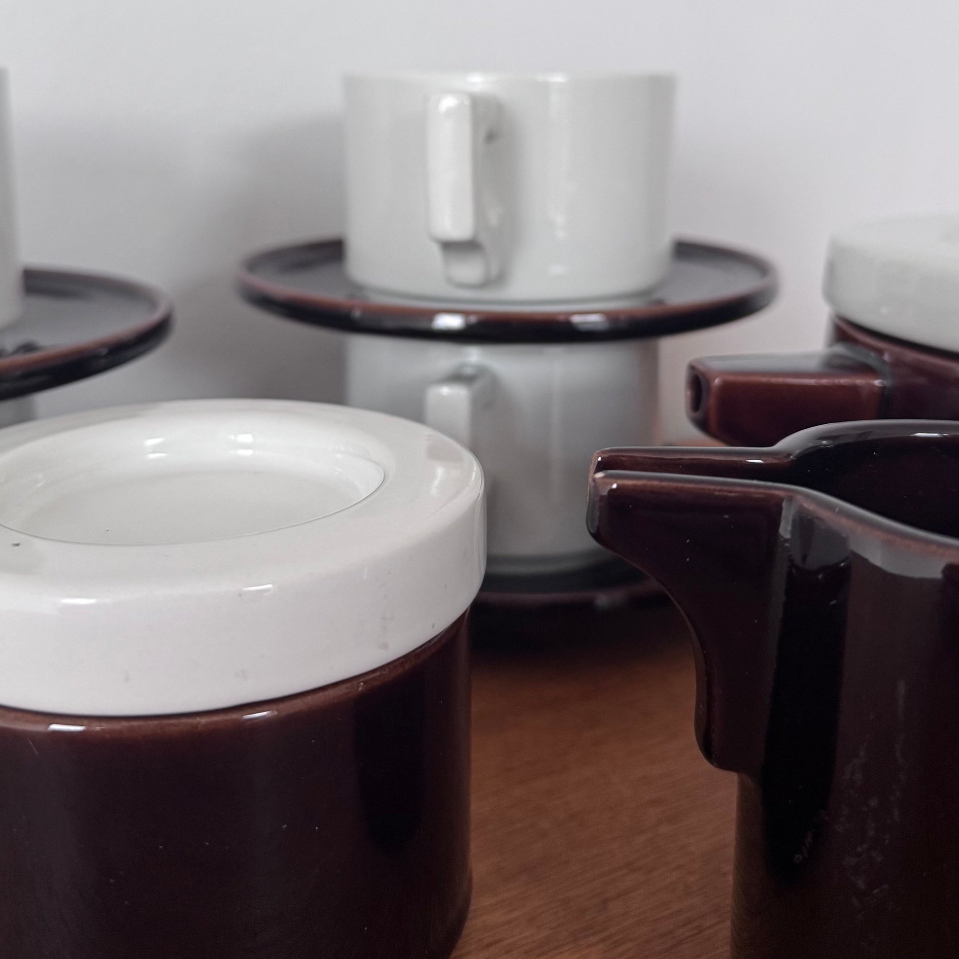 Vintage Italian Modernist ceramic tea and coffee set featuring deep brown glaze with white accents, including cups, saucers, teapot, creamer, and sugar jar.